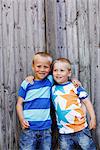 Boys standing with arms around, smiling