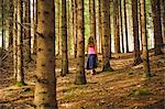 Girl walking among trees in forest