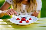 Girl eating yogurt with strawberries, Sweden.