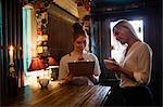 Waitress discussing the menu with the customer in the bar