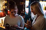 Waitress discussing the menu with woman in the bar