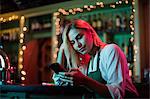 Waitress using her mobile phone at the bar counter