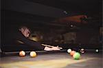 Young man playing pool playing pool in the billiards club