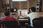 Audio engineers using sound mixer in recording studio