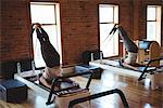Women practicing pilates on reformer in fitness studio