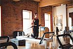 Woman practicing pilates on reformer in fitness studio