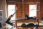 Determined women practicing pilates in fitness studio