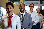 Portrait of female staff and passengers standing in the airport terminal