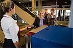 Businesswoman in queue receiving passport and boarding pass at airport terminal