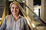 Portrait of businesswoman standing on escalator in airport