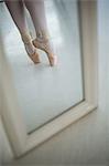 Reflection of ballerinas feet practicing ballet dance in the studio