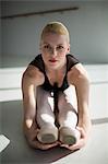 Ballerina stretching on the floor at studio