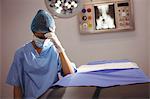 Sad female nurse sitting in operation theater at hospital