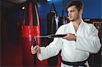 Karate player practicing with nunchaku in fitness studio