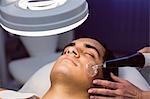 Man getting a facial massage for cosmetic treatment at clinic