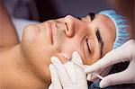 Man receiving botox injection on his face at clinic