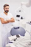 Dentist standing with his arms crossed in clinic