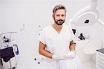 Portrait of dentist standing in clinic