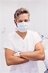 Dentist standing with his arms crossed in clinic