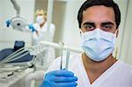 Portrait of dentist holding dental tools in dental clinic