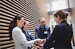 Businesspeople stacking hands together in office