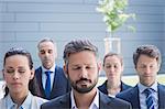 Group of business people with eyes closed standing outside office building