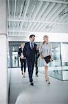 Confident businessman walking with colleagues inside office building