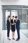 Businessman and colleague discussing over digital tablet inside office building