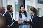 Group of businesspeople having a discussion near staircase in office