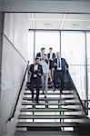 Confident businesspeople standing on staircase in office