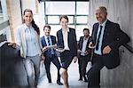 Portrait of confident businesspeople standing on staircase in office