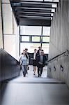 Portrait of confident businesspeople standing on staircase in office