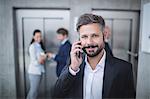 Businessman talking on mobile phone in office