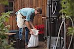 Man holding sack of barley into wort to make beer at home brewery