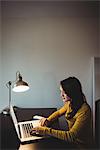 Woman working on laptop in study room at home