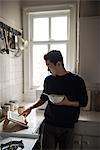 Man using digital tablet while having breakfast at home