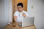 Man using mobilephone while having a cup of coffee at home