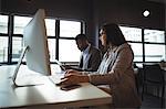 Businessman and a colleague working at their desk in office