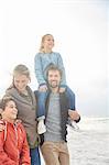 Smiling family walking on winter beach