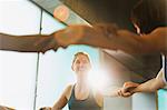 Smiling women joining arms in exercise class gym studio