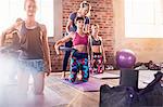 Fitness instructor helping young woman with pilates ring in exercise class gym studio