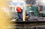 Welder using welding torch in steel factory