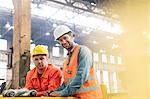 Portrait confident steel factory workers in factory