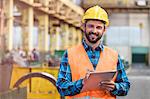 Portrait smiling steel worker with clipboard in factory