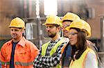 Steel workers listening in meeting in factory