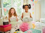 Portrait smiling girls holding birthday gifts