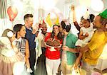 Multi-ethnic multi-generation family celebrating birthday with chocolate cake