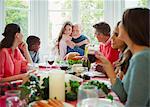 Granddaughter hugging grandfather at Christmas dinner table