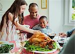 Multi-ethnic family enjoying Christmas turkey dinner at table