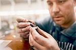 Focused male jeweler assembling jewelry in workshop